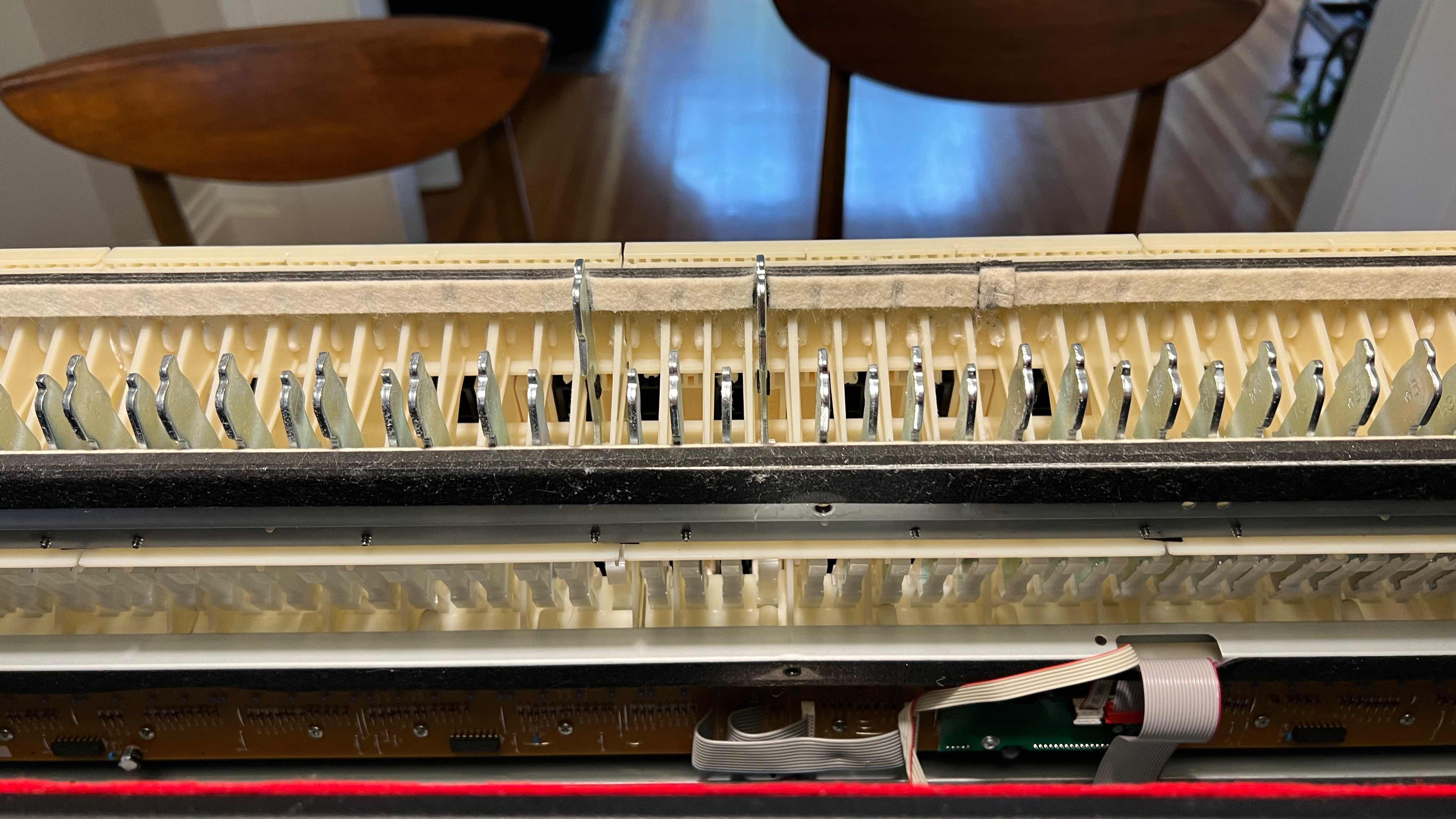 Here are the F (on the right) and A above middle C in their stuck positions; you can see the repair I did earlier to Middle C on the right! (For orientation, the keybed is pulled out and at a 90-degree angle; the keys are on the other side.)